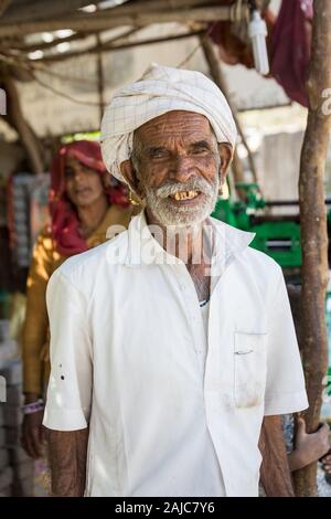 Udaipur, India - 06 Marzo 2017: ritratto di un vecchio in un turbante bianco. L'uomo sorride e guarda gioiosa. Foto Stock