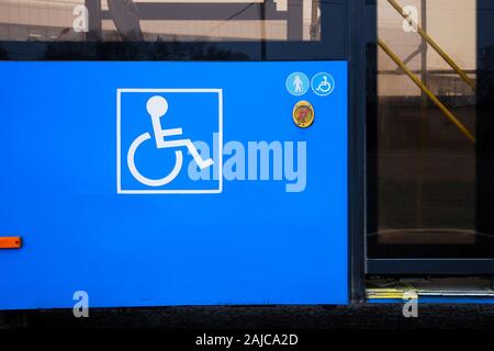 Disabilità e anziano icona sul bus pubblico accanto ad automatico porte in vetro e di emergenza Pulsante di allarme Foto Stock