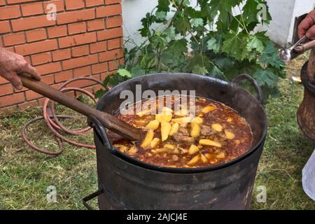 Stufato tradizionale cottura in un metallo grande calderone all'aperto. Foto Stock
