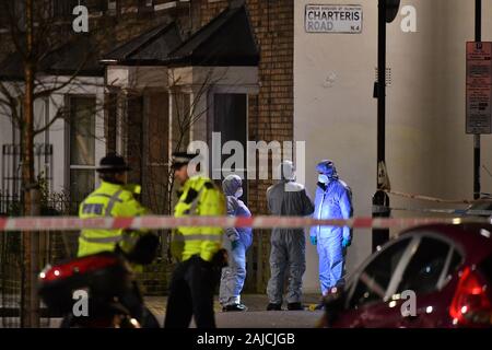 Forensic officer presso la scena del crimine dopo la Metropolitan Police cordon Charteris off road vicino alla giunzione con il sig. Lennox Road a Finsbury Park dopo che un uomo è stato pugnalato a morte nel nord di Londra il venerdì sera. Foto Stock