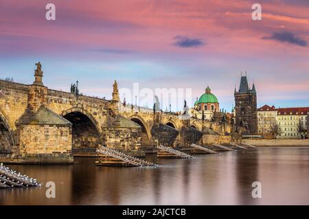 Praga, Repubblica Ceca - il famoso Ponte Carlo (Karluv most) con un bel cielo viola e del tramonto su un pomeriggio invernale Foto Stock