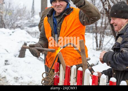 Lavoratori nei servizi municipali sono la riparazione di un tubo rotto. Foto Stock