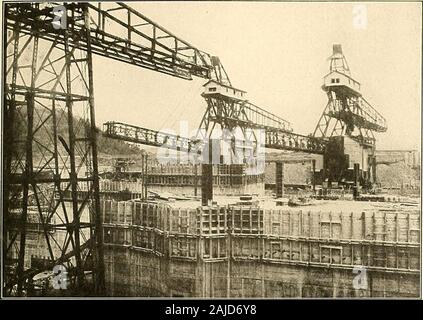 Panama e il canale di immagine e prosa .. . La parete di bloccaggio di Gatun che mostra la costruzione ad arco il colossale lavoro concreto a GATUN 183. Pbolo da Underwood & Underwood gru a ponte al lavoro montato su rotaie queste gru portano il fardello più pesante. Thosedehvering concreti di forme. Una gru avrà un costo di vapore fischietti suonò squillante avvertenze e crypticorders. Ruote rumbled. Pulegge creaked. Itseemed che tutto ciò che un uomo potesse fare era beingdone dalla macchina, eppure c'era un esercito di mendirecting, correggendo e integrando la me-chanical manodopera. Nelle serrature a Gatun andrà 2.000.000 cubic Foto Stock