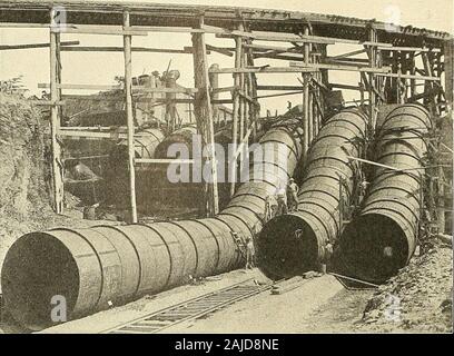 Panama e il canale di immagine e prosa .. . Parzialmente completata stramazzo, 1913Il fiume era basso quando questa foto è stata scattata. In acqua alta si scorrerà attraverso il completamento della struttura mostrata a destra i8o Panama e il canale della forza em-ployed contro di essa,il suo resistere poweris aumentata. Forza Itresists ex-erted horizontallyprecisely come anarch resiste alla forza,o peso, exertedfrom sopra. Thedam al spill-modo si estende sol-folle attraverso theopening a aheight di 69 piedi.Ma questo è 16metri sotto il livello di thenormal delcarrello Lago. Dalla parte superiore della diga thesolid risethirteen piloni in cemento per una altezza come pl Foto Stock