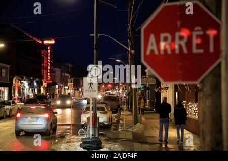 La vista notturna di Rue principale con il cartello di stop in francese Arret in primo piano. La strada principale. Città Di Magog.Quebec.Canada Foto Stock