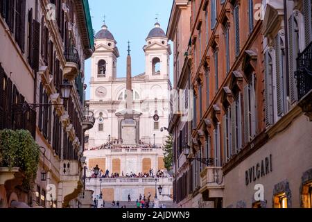 Piazza di Spagna View da Via dei Condotti al crepuscolo, turisti e chiesa di Trinita' dei Monti, Roma, Italia Foto Stock