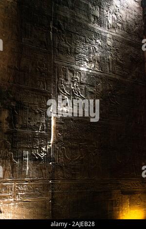 Geroglifici illuminata all'interno del santuario al centro della egiziano Tempio di Horus in Edfu, in Egitto. Foto Stock