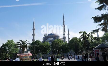 ISTANBUL, Turchia - 30 luglio 2019: i turisti a piedi lungo la spaziosa piazza della città vicino alla splendida antica moschea con alti minareti in Istanbul il 30 luglio a Istanbul Foto Stock