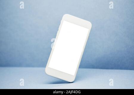 Telefono cellulare mockup con il bianco schermo vuoto o spazio copia alla moda su sfondo blu. Foto Stock