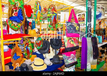 Puerto Limon Costa Rica - 8 Dicembre 2019: etnico souvenir, berretti da baseball, sacchetti con vari pattern appesi in strada del mercato Foto Stock