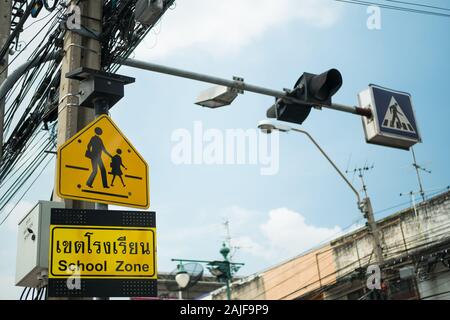 Giallo zona scuola di avvertimento posta sul ciglio della strada a Bangkok, Tailandia. Foto Stock