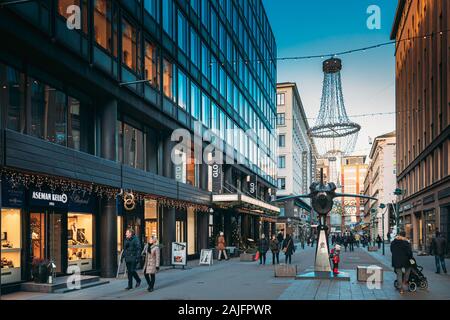 Helsinki, Finlandia - 10 dicembre 2016: la gente che camminava sul Kluuvikatu Street nel giorno d'inverno. Street decorato per il Natale e il nuovo anno Vacanze Foto Stock