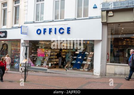 Negozio di scarpe per ufficio a Bournemouth, Regno Unito. Facciata bianca con cartellonistica blu "OFFICE", grande finestra che mostra le calzature sugli scaffali, 20% di sconto visibile. Foto Stock