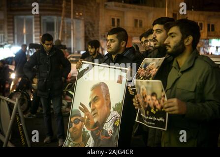 Tehran, Iran. 3 gennaio, 2020. Le persone in attesa di poster di Qasem Soleimani, un alto comandante iraniano, durante una cerimonia di lutto a Tehran, Iran, Gen 3, 2020. Un attacco nei pressi di Baghdad International Airport venerdì ha ucciso Qasem Soleimani, e Abu Mahdi al-Muhamdis, vice primo leader dell'Iraq Hashd paramilitari Shaabi forze. Credito: Ahmad Halabisaz/Xinhua/Alamy Live News Foto Stock