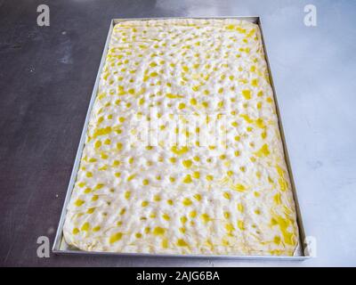 Un vassoio di focaccia genovese prima della cottura, la focaccia è un piatto da forno pane italiano prodotto, ricetta tradizionale dalla Regione Liguria Foto Stock