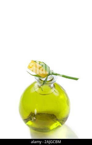 Oli essenziali di bottiglie con fresche rose giallo sulla parte superiore, botanico Trattamento aromaterapia Foto Stock