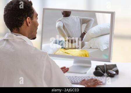 Medico con uno stetoscopio sul computer allo schermo del laptop. la telemedicina o la telesanità concetto, dolore alla schiena Foto Stock