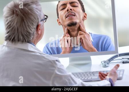 Medico con uno stetoscopio sul computer allo schermo del laptop. la telemedicina o la telesanità concetto, mal di gola, Foto Stock