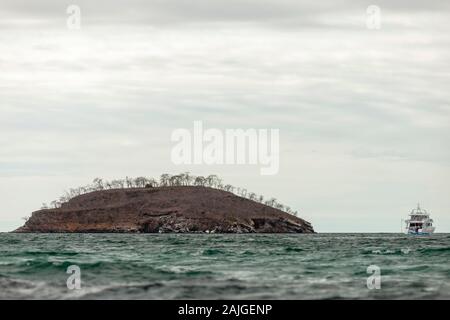 La barca turistica e isolotto vicino a Elizabeth Bay, Isabela island, Galapagos, Ecuador. Foto Stock