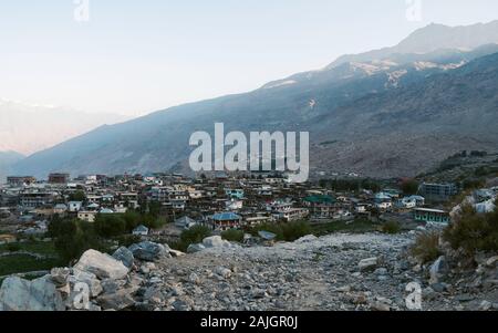 Nako villaggio fiancheggiato da campi, alta montagna himalayana, e sentiero roccioso nella Spiti valley a sunrise in Himachal Pradesh, India. Foto Stock