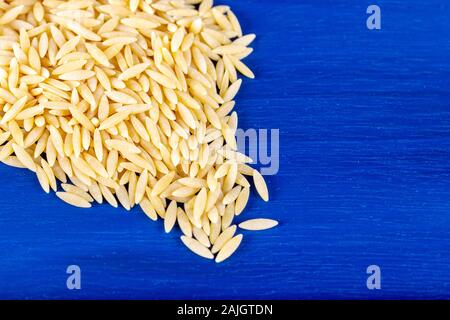 Orzo noodle grani su sfondo blu. Foto Stock