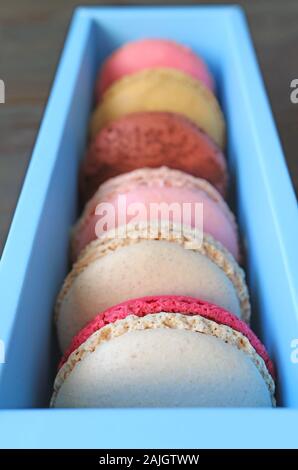 Closeup assortimento di colori pastello Macaron pasticceria in light blue box Foto Stock