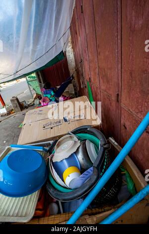 Stoviglie resto vicino a scatole di cartone che servono come un frangivento per stufe usata per cuocere alimenti con accettori poveri a loro un rifugio in Kampong Cham, Cambogia. Foto Stock