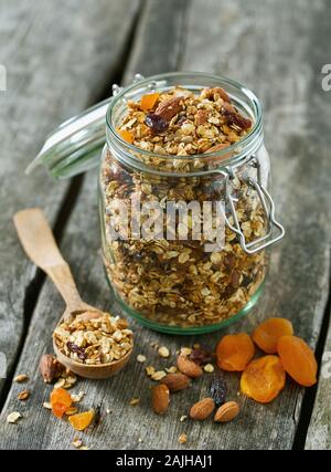 Granola nel vasetto di vetro sul tavolo di legno Foto Stock