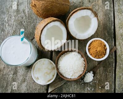 Lo zucchero di cocco, latte e olio sulla superficie di legno Foto Stock