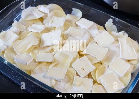 Con Tartiflette reblochon prima della cottura in un piatto di vetro Foto Stock