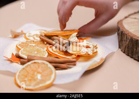Le donne la mano facendo decorazioni da essiccato arance, stelle dal mandarino e cannella. Girls party o riunione. Foto Stock