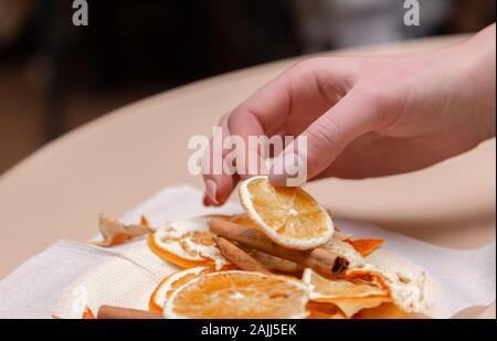 Le donne la mano facendo decorazioni da essiccato arance, stelle dal mandarino e cannella. Girls party o riunione. Foto Stock