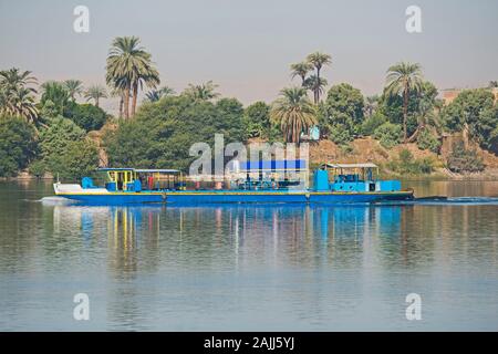 Vecchio tradizionale chiatta viaggiare in barca sul fiume Nilo attraverso rurale africana paesaggio di campagna con palme Foto Stock