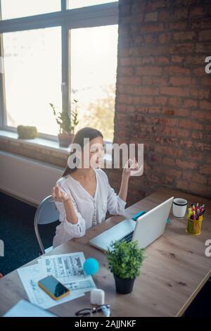 Attraente giovane donna avente un minuto per rilassarsi Foto Stock