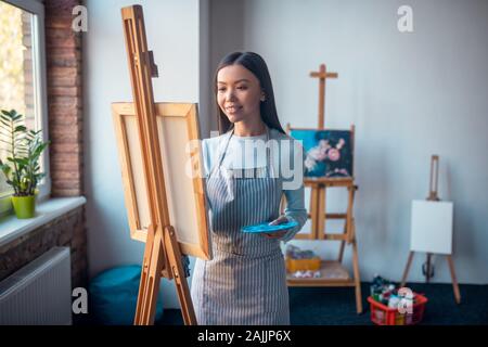 Gioiosa dai capelli lunghi donna godendo della sua professione Foto Stock