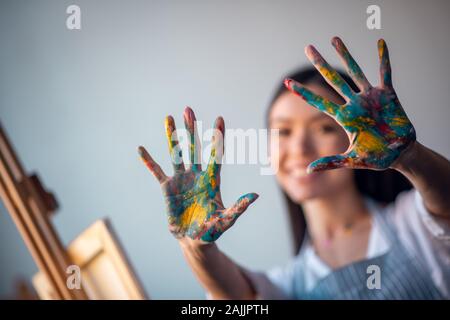 Messa a fuoco selettiva delle mani di vernice essendo mostrata a voi Foto Stock