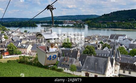 Il turista scatta la foto dalla funivia aerea alta sopra i vigneti e la città medievale di Rudesheim che domina il fiume Reno. Foto Stock