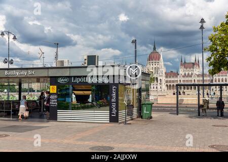 Budapest metropolitana entrata lungo il Danubio e ungherese opposto del Palazzo del Parlamento Foto Stock