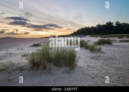 Alba sopra le capanne sulla spiaggia e dune di sabbia di Wells vicino alla spiaggia del mare, Wells-next-the-Sea, Norfolk, Inghilterra, Regno Unito, Europa Foto Stock