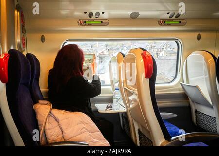 Una donna passeggero in un treno pendalino prendendo immagini su iPad fuori della finestra a Lancaster Foto Stock