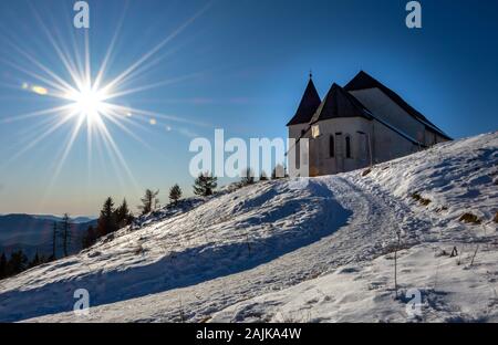 Uršlja gora, Slovenia - Gennaio 2, 2020; il picco Uršlja gora in Slovenia con chiesa San Uršula. Un picco solitario nel cuore della regione di Koroška. Foto Stock