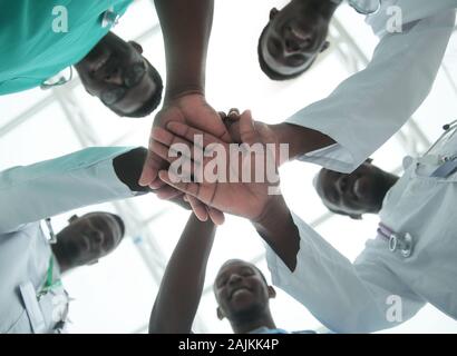 Close up. gruppo internazionale di medici di mettere le loro mani insieme Foto Stock