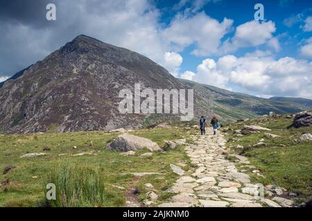 Escursionisti nella valle di Ogwen, Snowdonia National Park, Galles del Nord, con Pen YR Ole Wen in lontananza Foto Stock