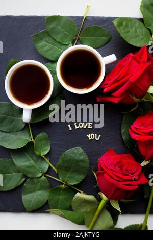 L'iscrizione ti amo su uno sfondo nero, caffè, rose rosse Foto Stock