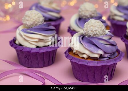 Tortini fatti in casa con crema di lilla su uno sfondo rosa, concept per il giorno di San Valentino o il compleanno, Primo Piano Foto Stock