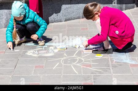 Samara, Russia - 25 Maggio 2019: giovani ragazze disegna su un marciapiede con gesso di colore. Al di fuori delle attività per i bambini in estate Foto Stock