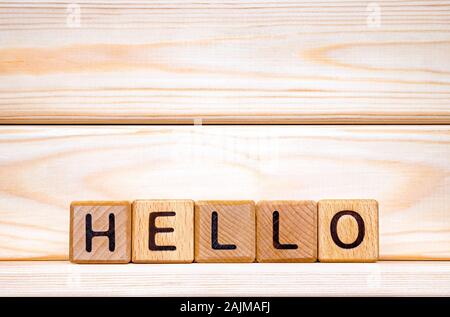 Hello Word di legno dello sfondo. Concetto di saluto. Ciao segno wriiten su cubetti. Invito al mondo. Parola hello scritto con cubetti di legno. Ciao sfondo. Benvenuto, salutate idea Foto Stock