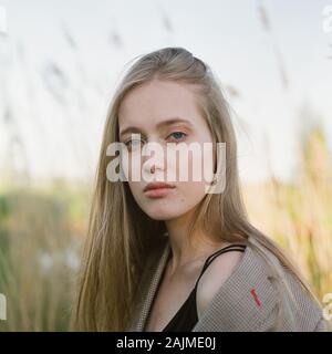 Una bella donna si erge tra le canne Foto Stock