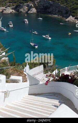 Ripidi gradini bianchi che scendono fino alla baia di Cala Llonga, a Ibiza, Isole Baleari, Spagna Foto Stock