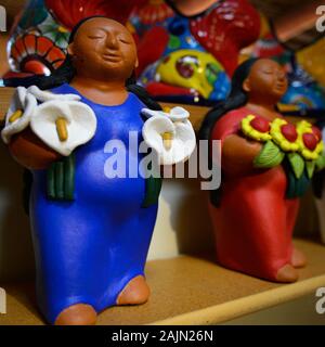 Un vintage stile Mixtec figurina donna indossa blu e tenendo calla Lillies culturali nel display delle arti a merchant in città artigianale di Tubac, AZ, Stati Uniti d'America Foto Stock